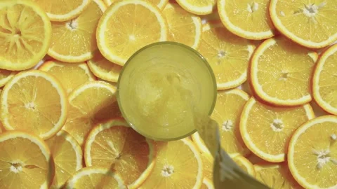 Background slow motion video of pouring orange juice into a glass. Vídeos de archivo 243009792
