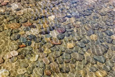 Background of small stones lying under water. Stones in the water. Foto stock