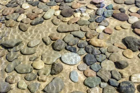 Background of small stones lying under water. Stones in the water. Foto stock