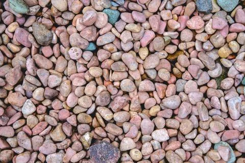 Background from small stones of a reddish hue. Stock Photos