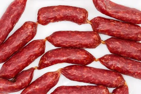Background of small thin dry cured sausages, fragment top view Stock Photos
