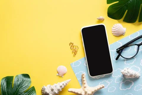 A background with a smartphone, glasses, a blank notepad and leaves and shell Stock Photos