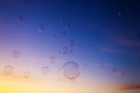 Background with soap bubbles floating in the sunset sky Stock Photos