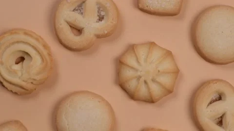 Background of spinning cookies on a beige or peach background, food trendy Stock Footage 197436737