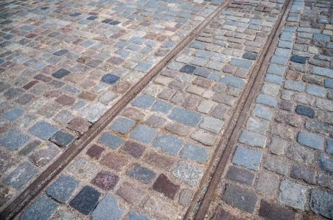 Background square of pavers with old rusty tram rails Stock Photos