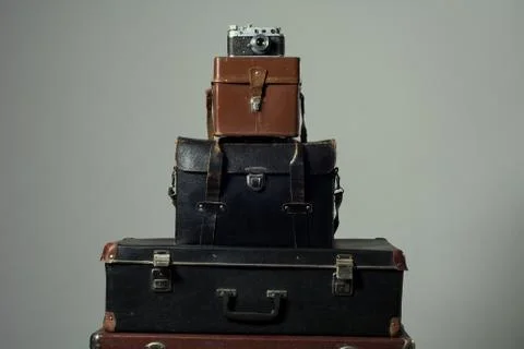 Background stack of old shabby suitcase with a camera in bag. Stock Photos