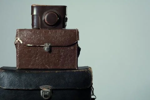 Background stack of old shabby suitcase with a camera in bag. Stock Photos