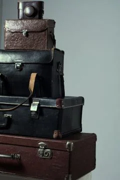 Background stack of old shabby suitcase with a camera in bag. Stock Photos