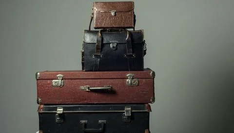 Background stack of old shabby suitcases form a tower Stock Photos