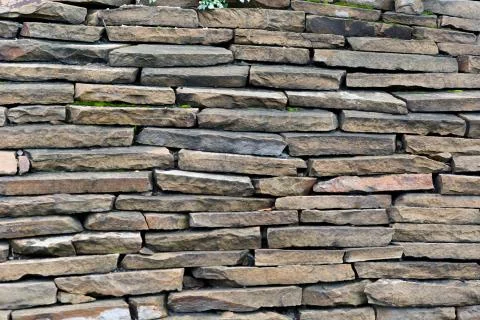 A background of stone blocks arranged in rows. Stock Photos
