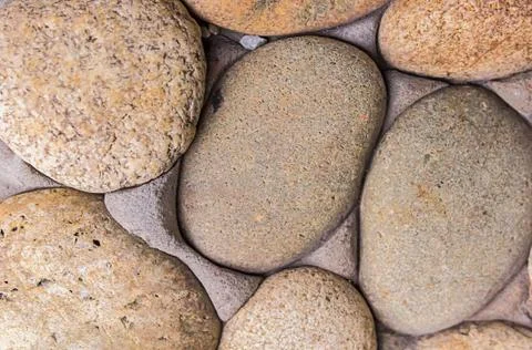 Background stone smooth pebbles light beige part wall close-up base geology s Foto stock