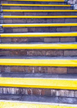 Background of a stone staircase with yellow steps. Sunny yellow staircase Foto stock