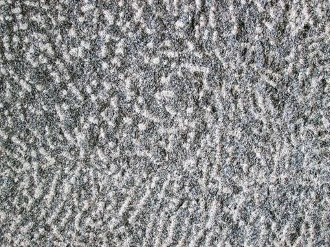 Background with a stone surface. A granite stone with potholes and roughness. Stock Photos