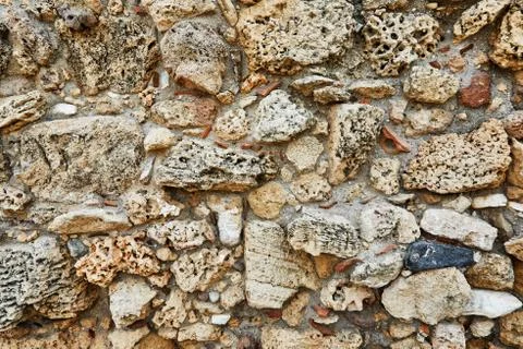 Background of the stone wall of the castle made of stones of different shapes Stock Photos
