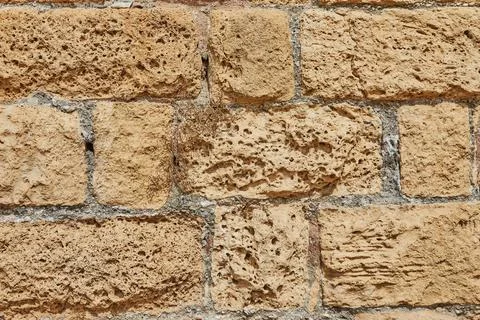 Background of the stone wall of the castle made of stones of different shapes Stock Photos