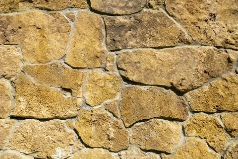 Background of stone wall texture. Yellow stone. Stock Photos