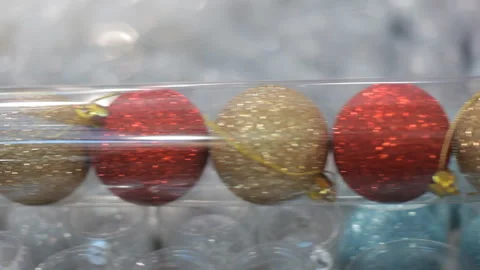 Background: a string of bright, sparkling multi-colored Christmas-tree balls. Video stock 98568882