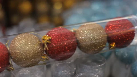 Background: a string of bright, sparkling multi-colored Christmas-tree balls. Stock Footage 98568925
