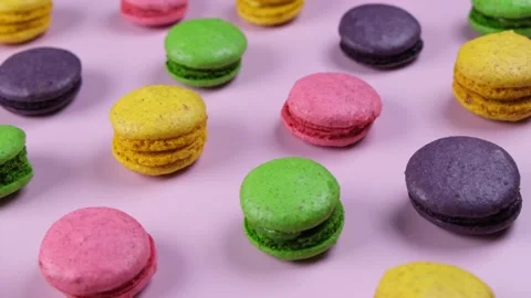 Background of sweet macaroon cookies in different colors on a pink background Stock Footage 245972630