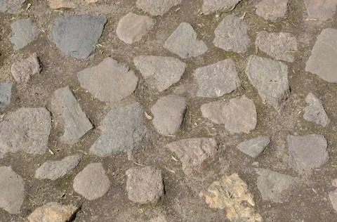Background, texture. Cobblestone pavement. A flat stone on an earthen surface Foto stock