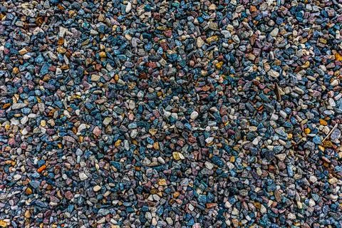 Background with the texture of colored rough pebbles. Dark wet pebbles. Photo Stock Photos