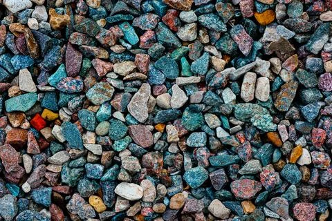 Background with the texture of colored rough pebbles. Dark wet pebbles. Photo Stock Photos