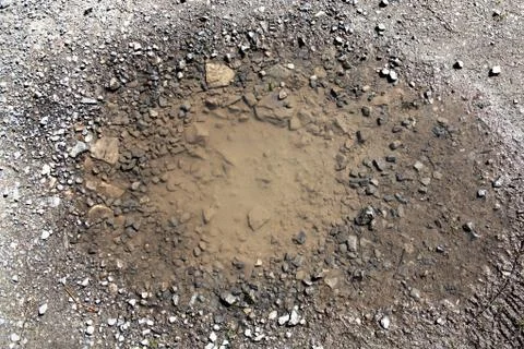 Background texture of damaged asphalt causing a pothole on a road surface whi Stockfoto's