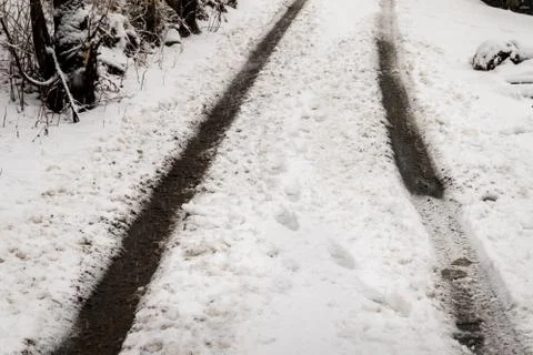 Background texture of dirt road covered with snow and tire tracks Stock Photos