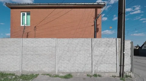 Background, texture of gray concrete fence and walls of the house made of red Stock Footage 127683732
