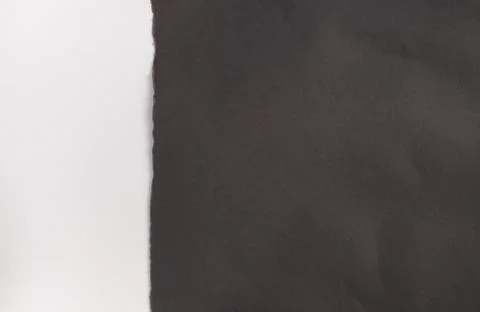 Background texture of gray paper with a torn off uneven edge. Stock Photos