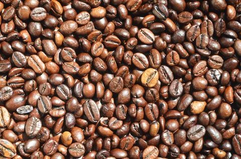 Background texture of a huge number of fragrant and fresh brown roasted cof.. Stock Photos