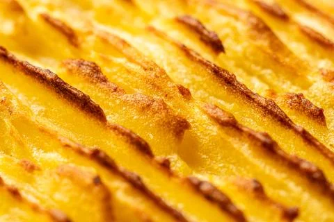 A background with the texture of mashed potatoes baked until golden brown in the Stock Photos