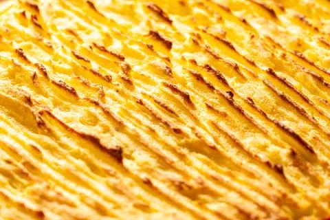 A background with the texture of mashed potatoes baked until golden brown in the Foto stock