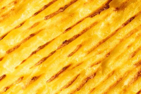 A background with the texture of mashed potatoes baked until golden brown in the Stock Photos