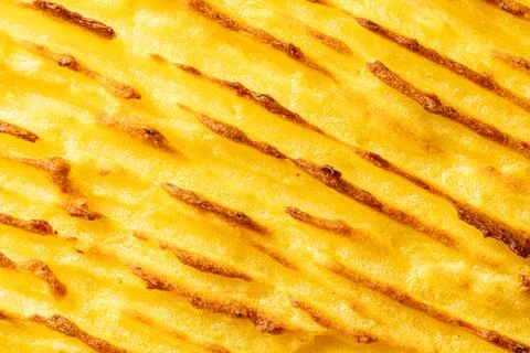 A background with the texture of mashed potatoes baked until golden brown in the Stock Photos
