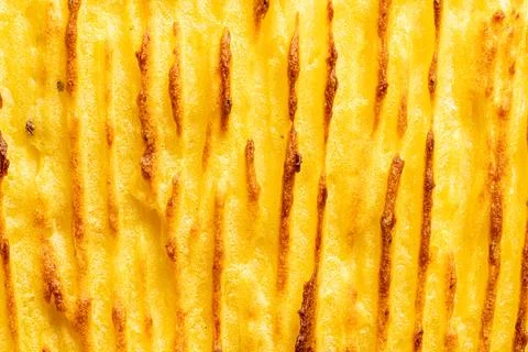 A background with the texture of mashed potatoes baked until golden brown in the Stock Photos