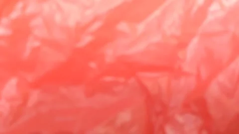 The background texture is matted and blurred from red plastic 스톡 동영상 286992007