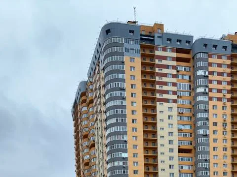 Background texture: multi-storey new house. Tall yellow-gray building in a ne Stock Photos