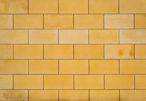 Background, texture of ocher-colored bricks from larger straight blocks Stock Photos