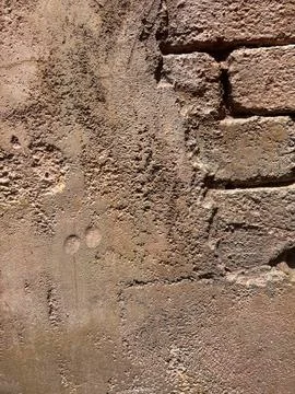 Background texture of old brick wall with incomplete flaking plaster covering Stockfoto's