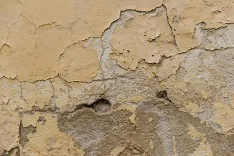 Background with texture of old peeling paint with yellow hue Stock Photos