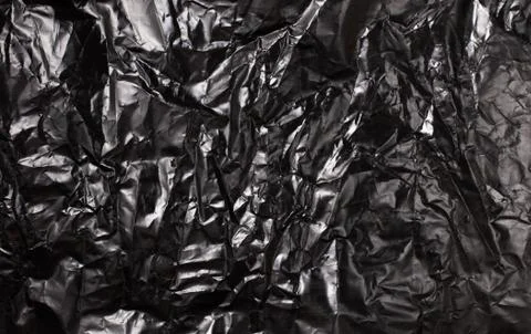 Background texture of a polyethylene shiny black film Stock Photos