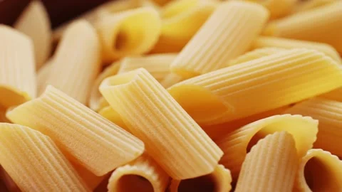 Background texture of raw Italian pasta. Penne, Penne Rigate. Top view, close-up Stock Footage 231931459