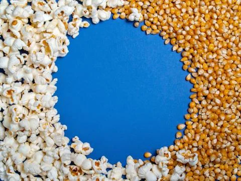 Background texture of ready popcorn and corn kernels on a blue background Stock Photos