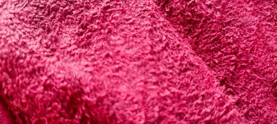 The background texture of the red fabric is irregular and wavy Foto stock
