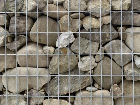 Background texture: river stones in a grid. Modern exterior, fence made of .. Stock Photos