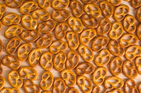 Background texture of salted savory mini pretzels in the traditional looped k Stock Photos