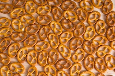 Background texture of salted savory mini pretzels in the traditional looped k Stock Photos