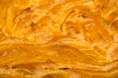 Background, texture of the surface of a baked cake with a crispy crispy crust Stock Photos