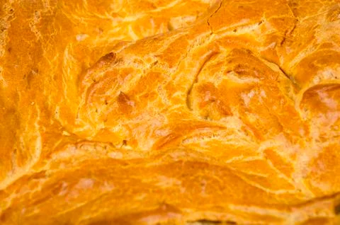 Background, texture of the surface of a baked cake with a crispy crispy crust Stock Photos